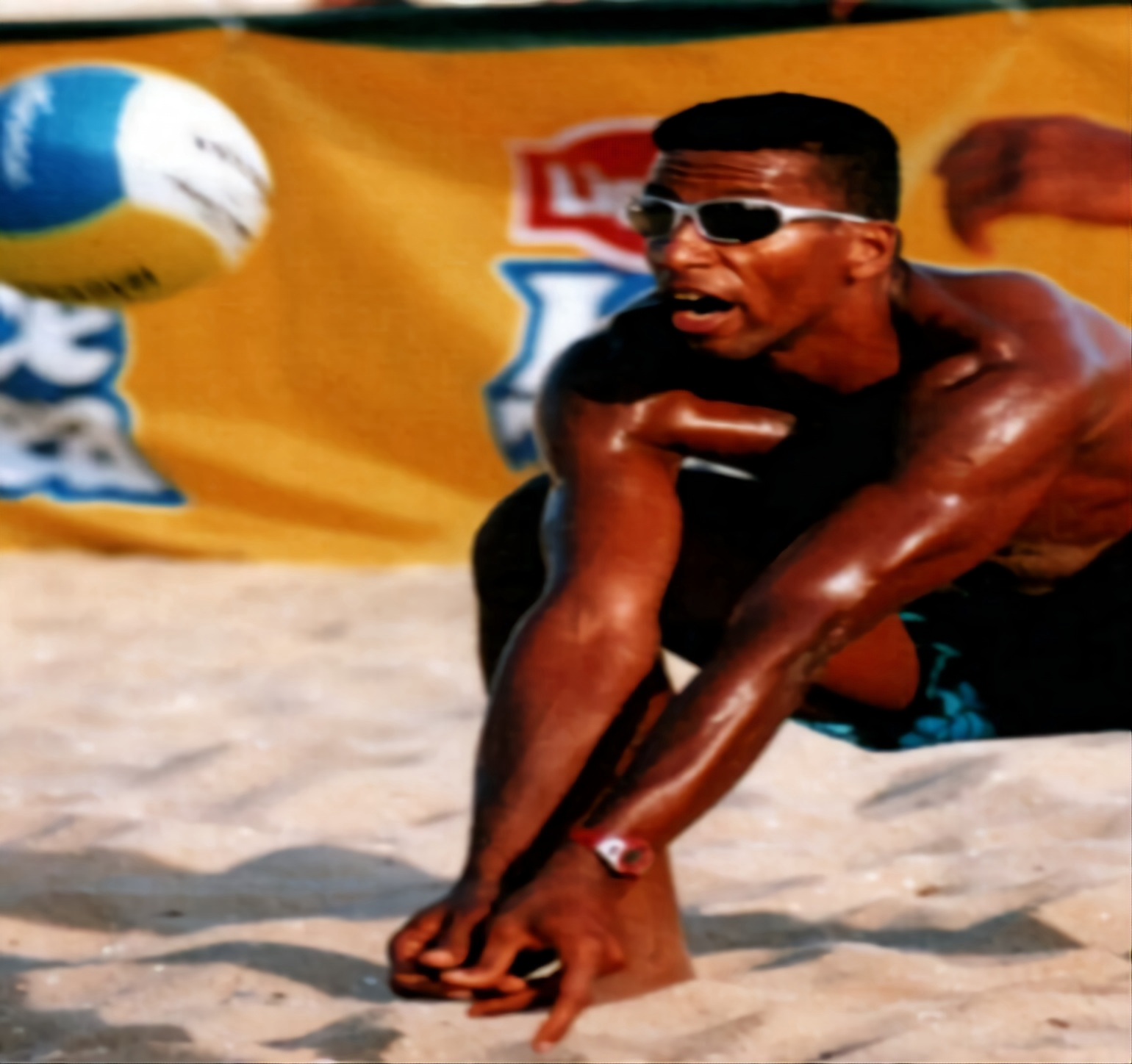 Beach volleyball player executing a low platform pass on the sand